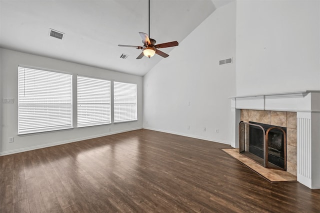 unfurnished living room with ceiling fan, high vaulted ceiling, dark hardwood / wood-style flooring, and a tile fireplace