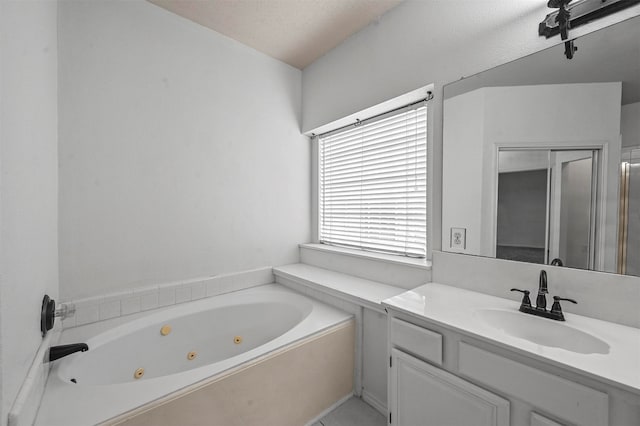 bathroom with vanity, a textured ceiling, and a tub