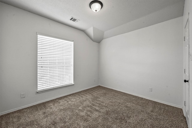 carpeted spare room featuring lofted ceiling and a textured ceiling