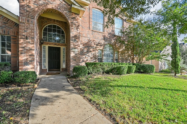 view of exterior entry with a lawn