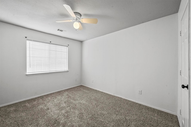 carpeted empty room with ceiling fan and a textured ceiling