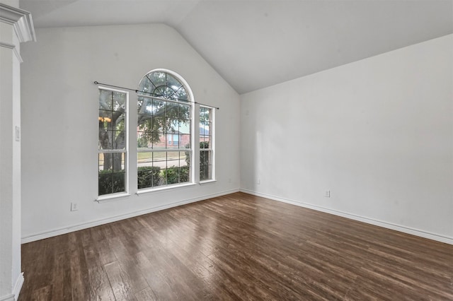 spare room with dark hardwood / wood-style flooring, vaulted ceiling, and a wealth of natural light