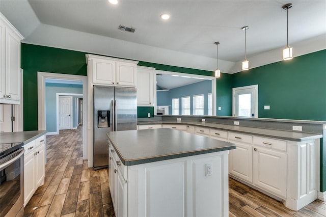 kitchen featuring dark hardwood / wood-style flooring, stainless steel appliances, white cabinetry, and hanging light fixtures