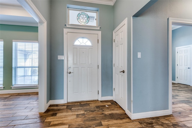 foyer entrance featuring crown molding, plenty of natural light, and dark wood-type flooring