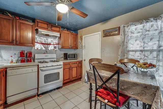 kitchen with light tile patterned floors, tasteful backsplash, white appliances, and ceiling fan