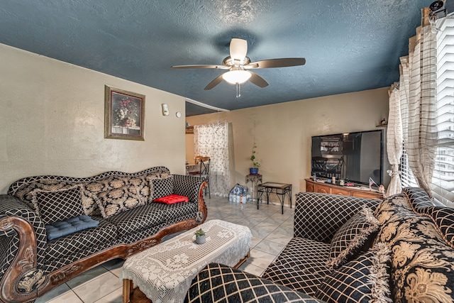 living room featuring a textured ceiling, ceiling fan, and light tile patterned flooring