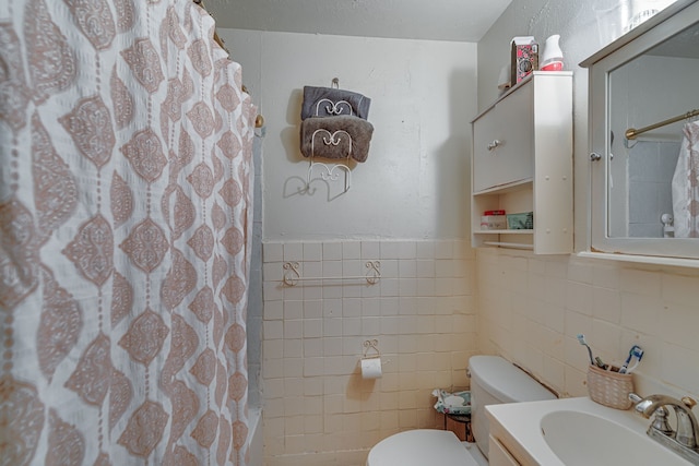 bathroom featuring toilet, vanity, tile walls, and walk in shower