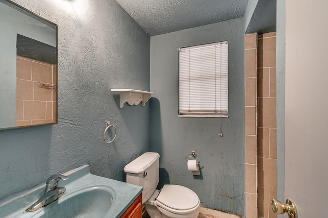 bathroom with vanity, a textured ceiling, and toilet