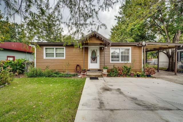 view of front facade featuring a front yard and a carport