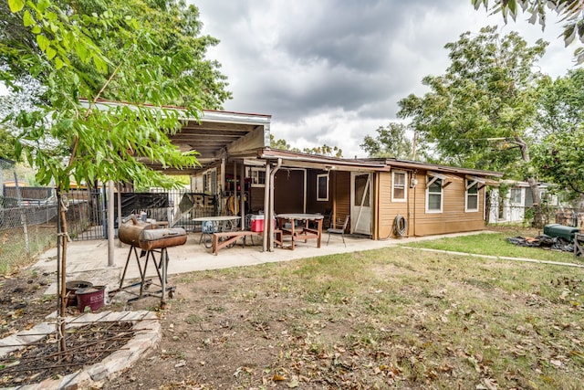 rear view of property featuring a patio area and a lawn