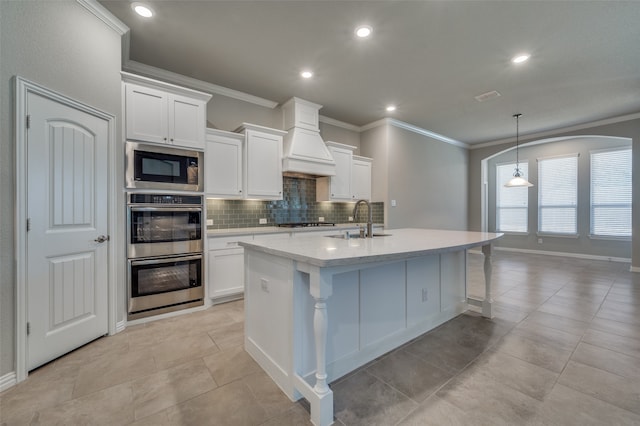 kitchen featuring white cabinets, appliances with stainless steel finishes, sink, and premium range hood