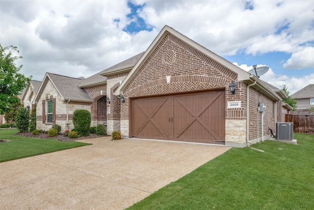 view of front of property with a garage, a front yard, and central air condition unit