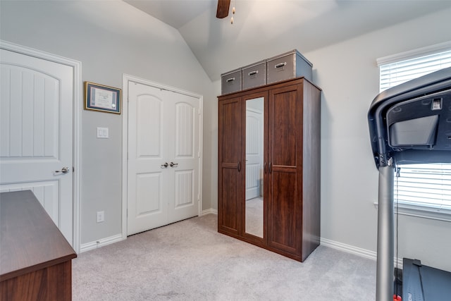 interior space with ceiling fan, light colored carpet, and lofted ceiling