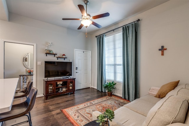 living room featuring dark wood-type flooring and ceiling fan