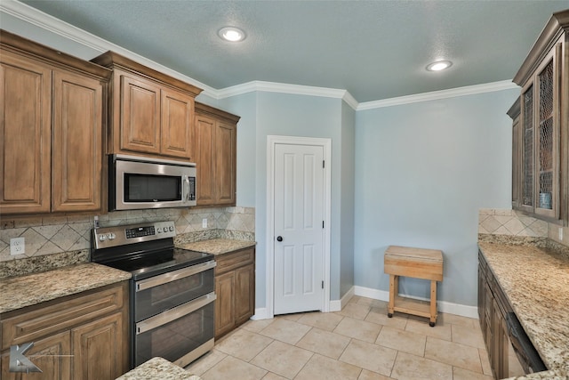 kitchen featuring stainless steel appliances, light stone counters, ornamental molding, tasteful backsplash, and a textured ceiling