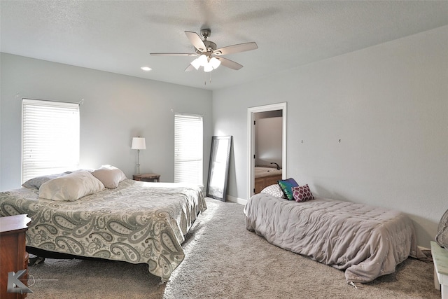 carpeted bedroom featuring ceiling fan and a textured ceiling