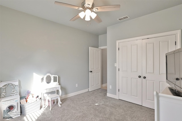 carpeted bedroom featuring ceiling fan and a closet