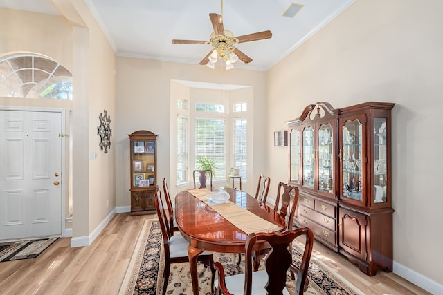 dining area with light hardwood / wood-style floors, ornamental molding, and ceiling fan