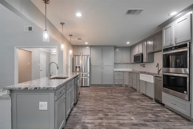 kitchen featuring gray cabinets, decorative light fixtures, sink, and stainless steel appliances