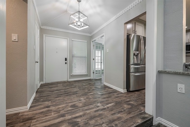 entryway featuring ornamental molding, an inviting chandelier, and dark hardwood / wood-style floors