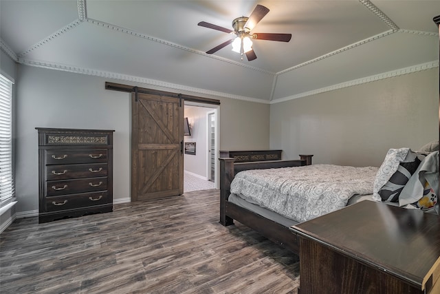 bedroom featuring lofted ceiling, ceiling fan, a barn door, ornamental molding, and dark wood-type flooring