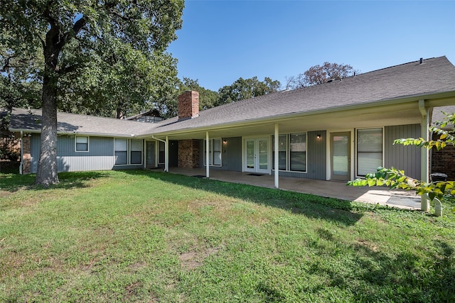 rear view of house featuring a patio and a yard