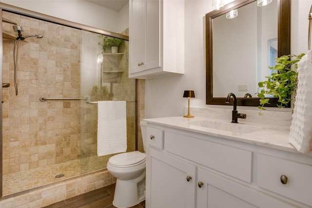 bathroom with a shower with shower door, wood-type flooring, toilet, and vanity