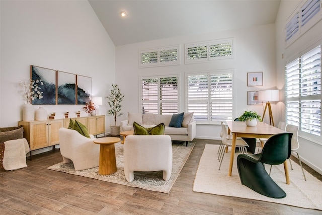 living room with high vaulted ceiling and wood-type flooring