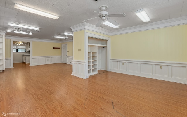 unfurnished living room featuring crown molding, decorative columns, light hardwood / wood-style floors, and ceiling fan