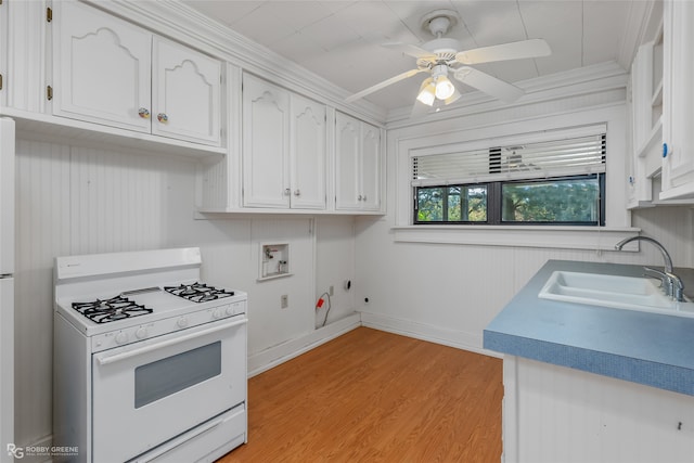 kitchen with sink, white cabinets, crown molding, and white gas range