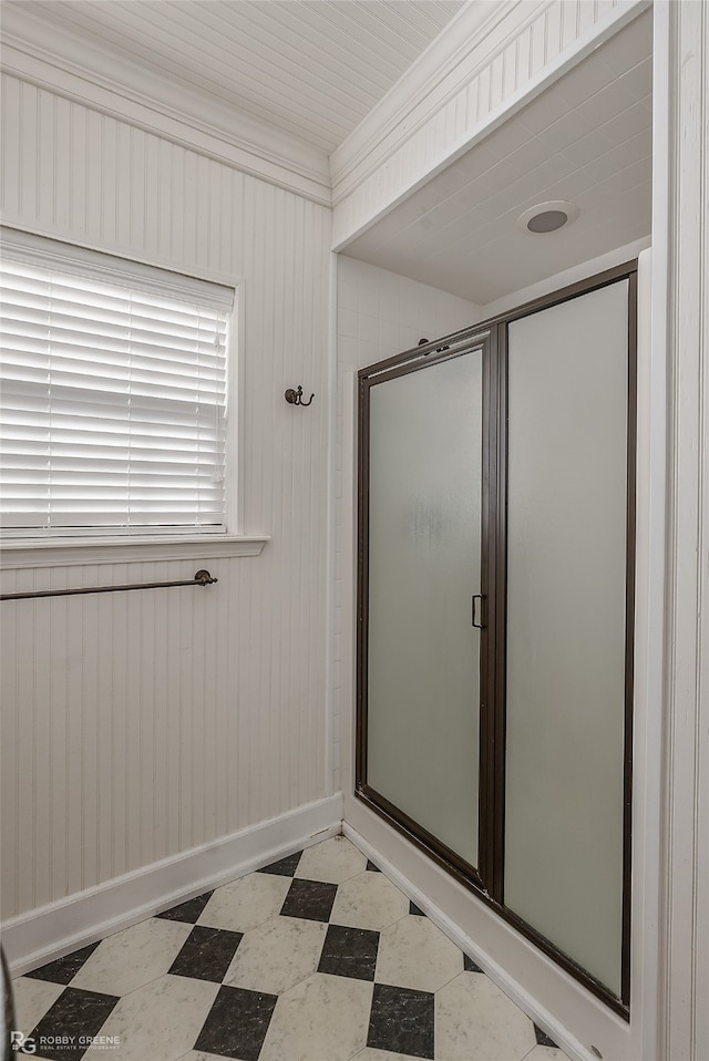 bathroom with an enclosed shower, wood walls, and crown molding