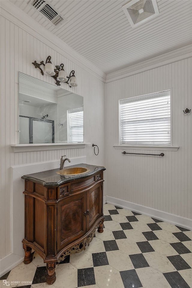 bathroom featuring vanity, wooden walls, ornamental molding, and walk in shower