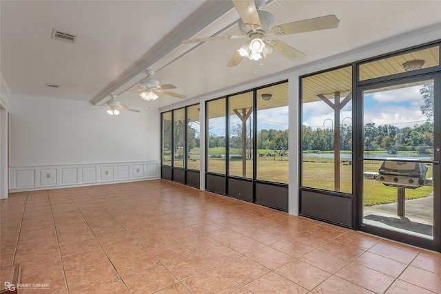 unfurnished sunroom featuring beam ceiling, ceiling fan, and plenty of natural light