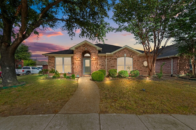 single story home featuring a lawn