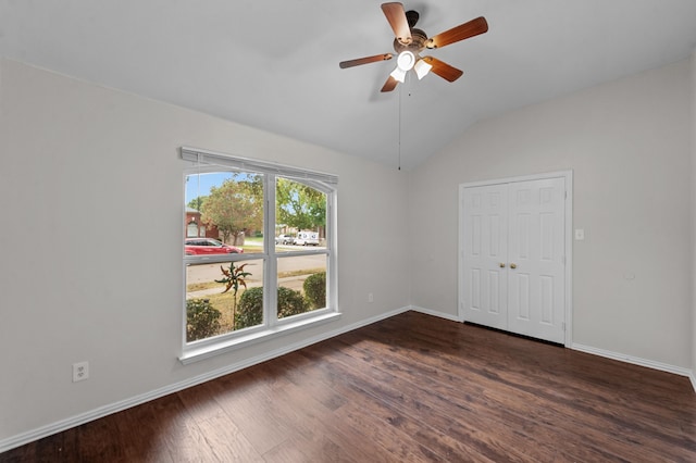 empty room featuring lofted ceiling, dark wood-type flooring, and ceiling fan