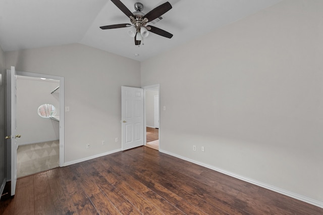 unfurnished bedroom featuring dark hardwood / wood-style flooring, lofted ceiling, a walk in closet, and ceiling fan