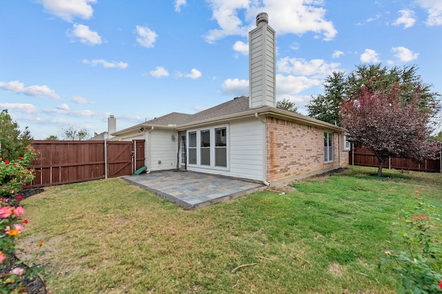 rear view of property featuring a patio area and a lawn