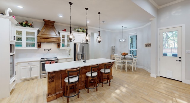 kitchen with stainless steel appliances, an island with sink, custom exhaust hood, and white cabinets