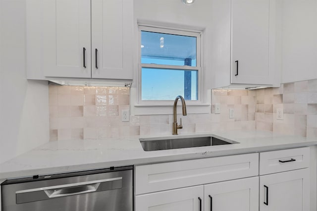 kitchen with sink, stainless steel dishwasher, white cabinetry, and light stone countertops