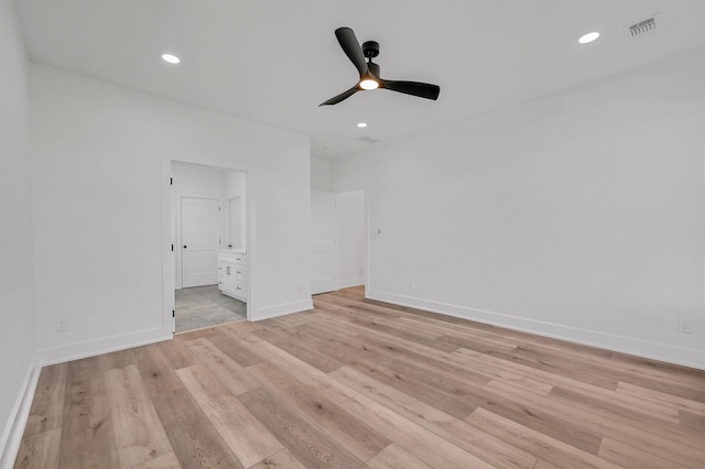 empty room with ceiling fan and light hardwood / wood-style floors