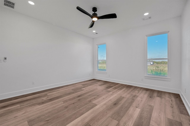 unfurnished room with ceiling fan, light hardwood / wood-style floors, and a healthy amount of sunlight