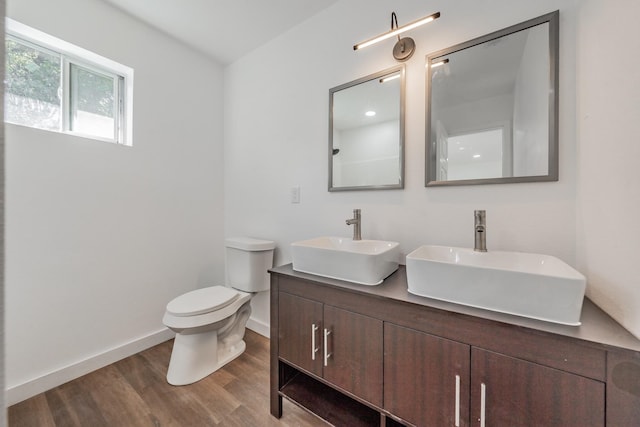 bathroom featuring vanity, wood-type flooring, and toilet