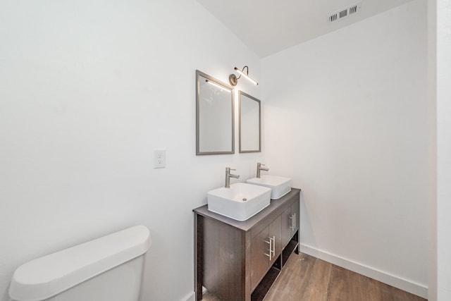 bathroom with vanity, toilet, and wood-type flooring