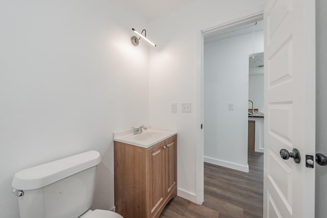 bathroom featuring toilet, hardwood / wood-style floors, and vanity