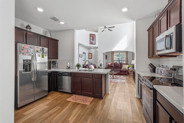 kitchen featuring light hardwood / wood-style floors, appliances with stainless steel finishes, sink, and decorative backsplash