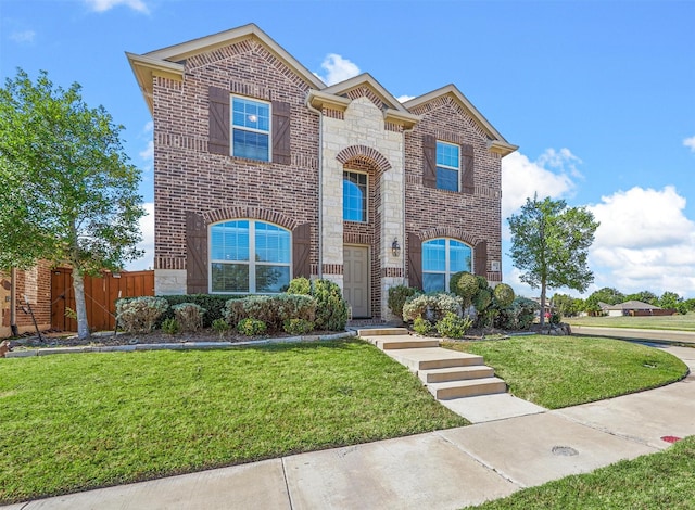 view of front of property with brick siding, fence, stone siding, and a front yard