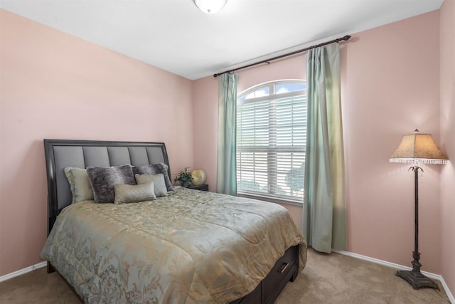 bedroom with baseboards and light carpet