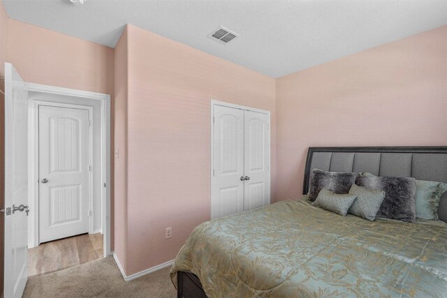 bedroom featuring a closet and light colored carpet