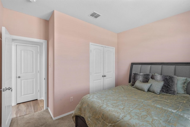 carpeted bedroom featuring baseboards, visible vents, and a closet