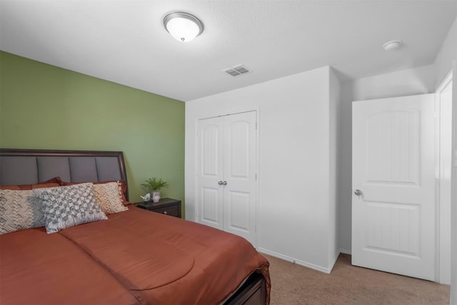bedroom with baseboards, visible vents, light carpet, and a closet